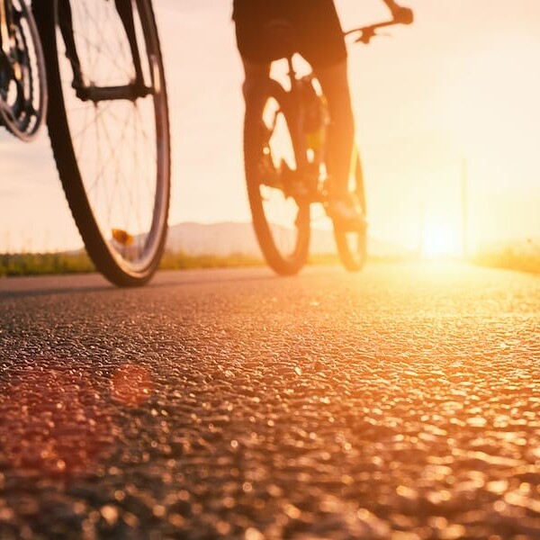 Bike wheels close up image on asphalt sunset road