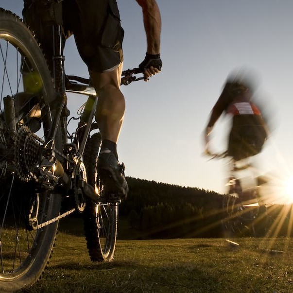 mountainbiker in rapidlyer goes direction sunset